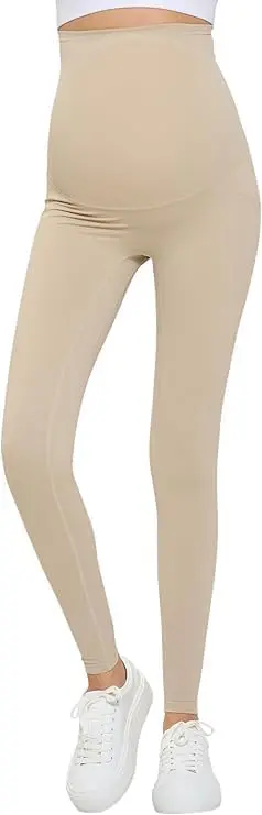 Wholesale beige maternity leggings with high waistband and side pocket detail, styled with white sneakers